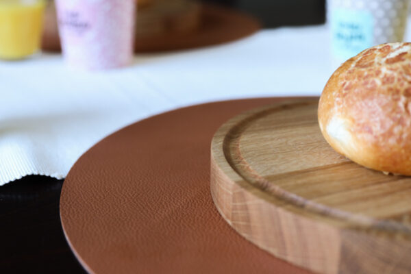Ronde broodplank aan een gedekte tafel