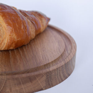 Ronde houten broodplank met croissant